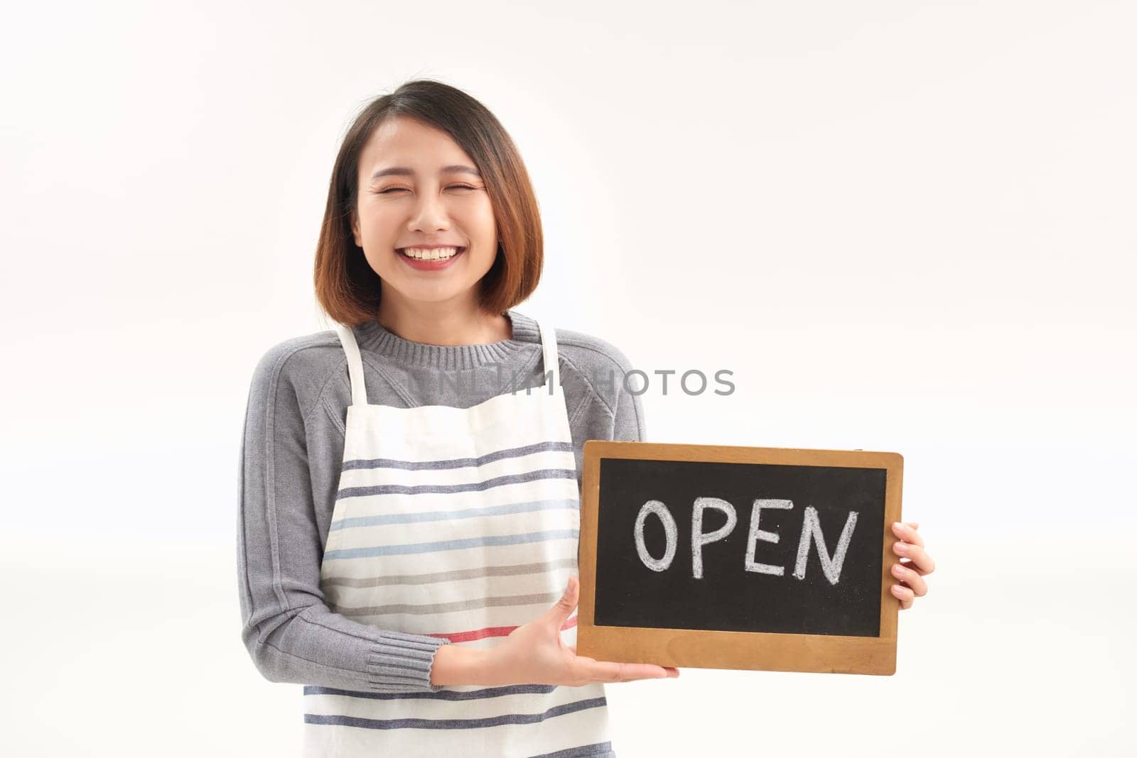 Portrait of young woman holding up an open signboard on white background by makidotvn