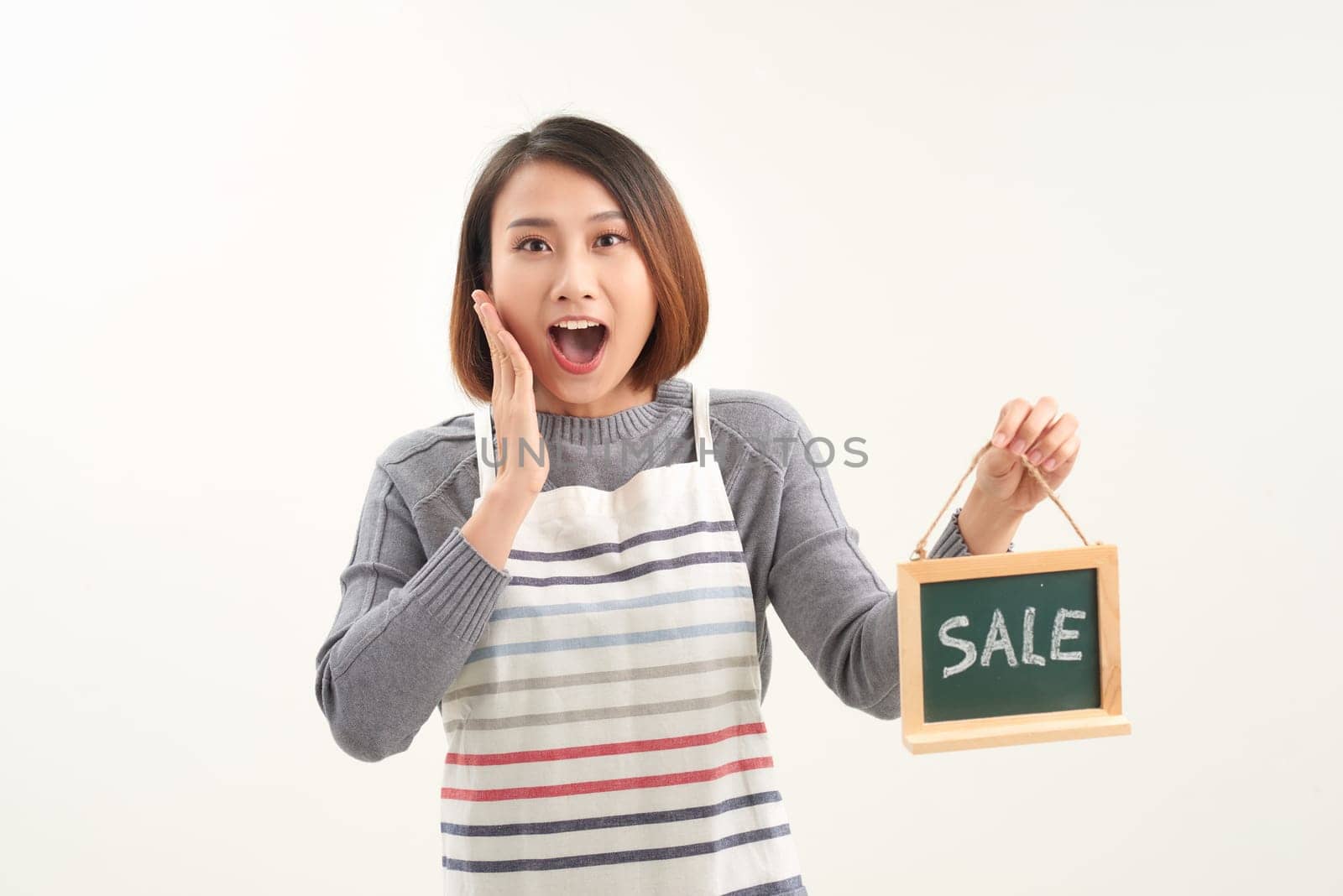 Asian woman holding sale board over white isolated background very happy and excited, with big smile and raised hands by makidotvn