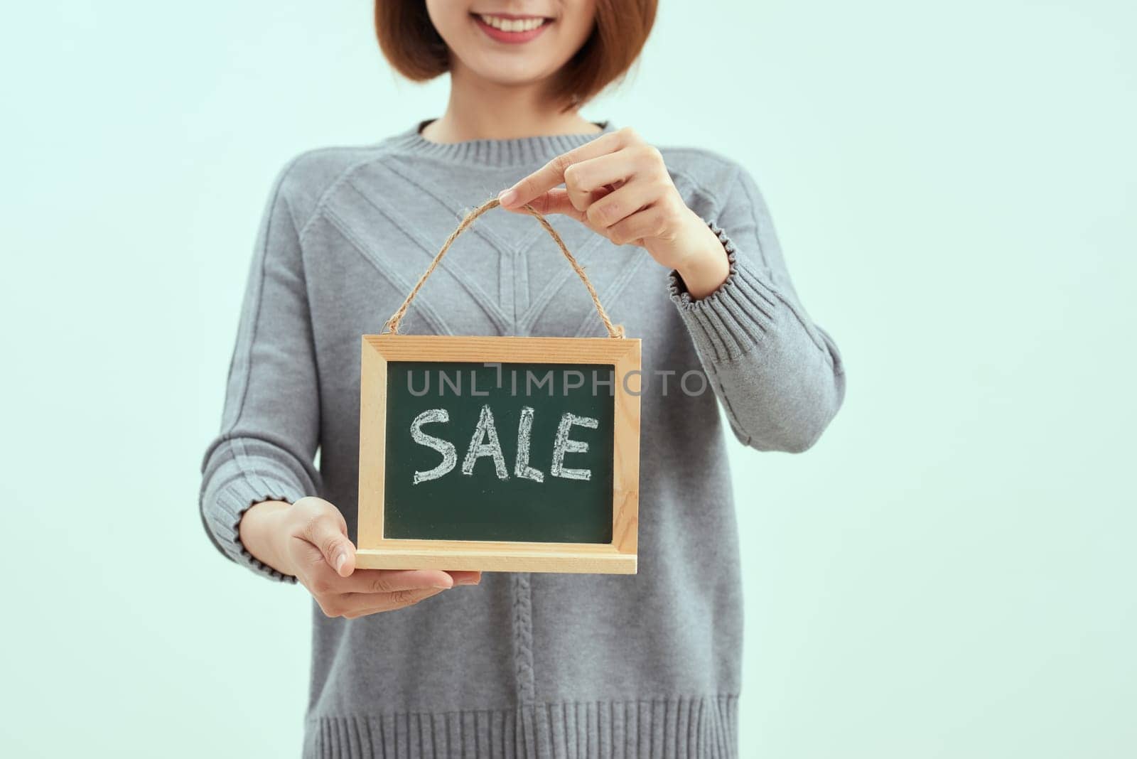 excited happy beautiful young woman with sale sign isolated over blue