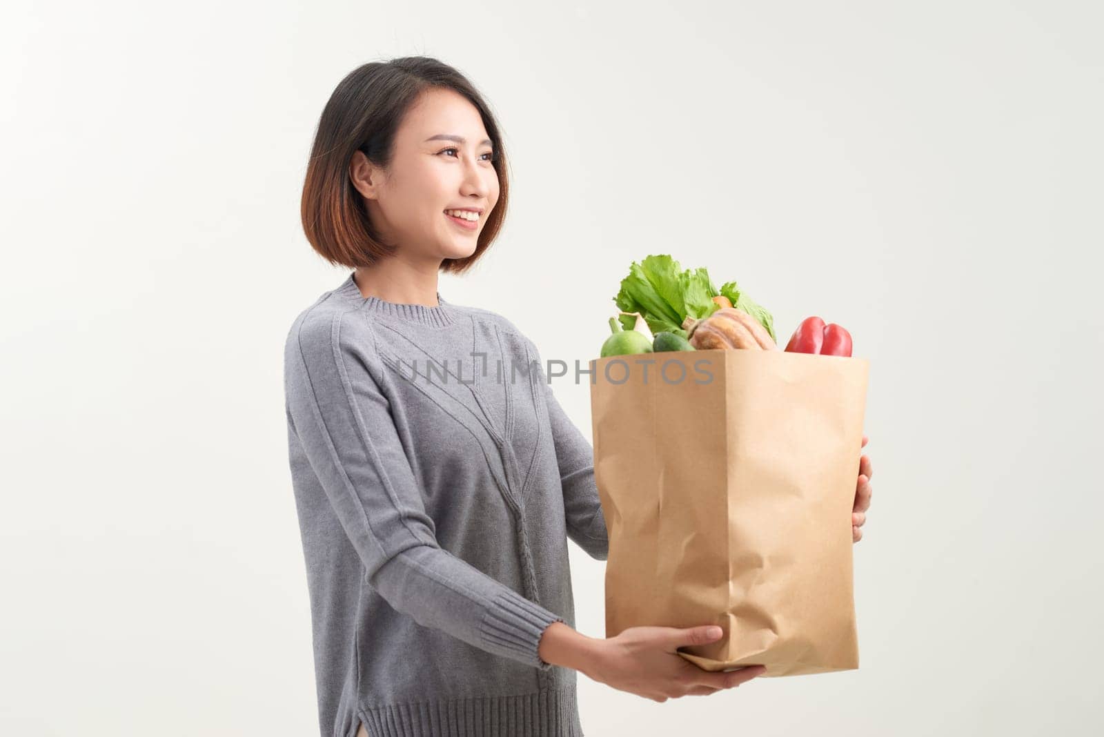 Young woman with a grocery shopping bag. Isolated on white background.