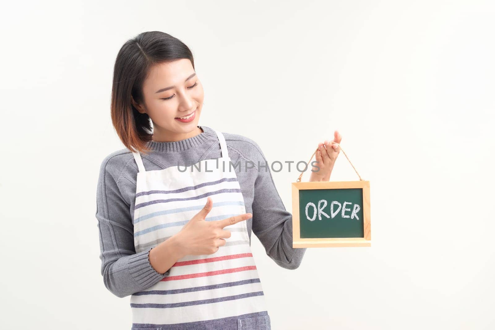 Portrait of smiling waitress showing chalkboard with order sign on white