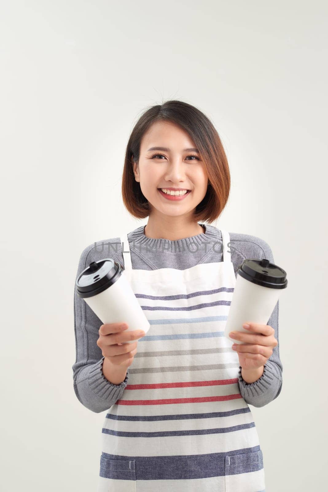 Close up photo beautiful amazing her she lady waitress owner cafeteria hold hands arms paper cups hot beverage invite visit cafe wear apron isolated white background