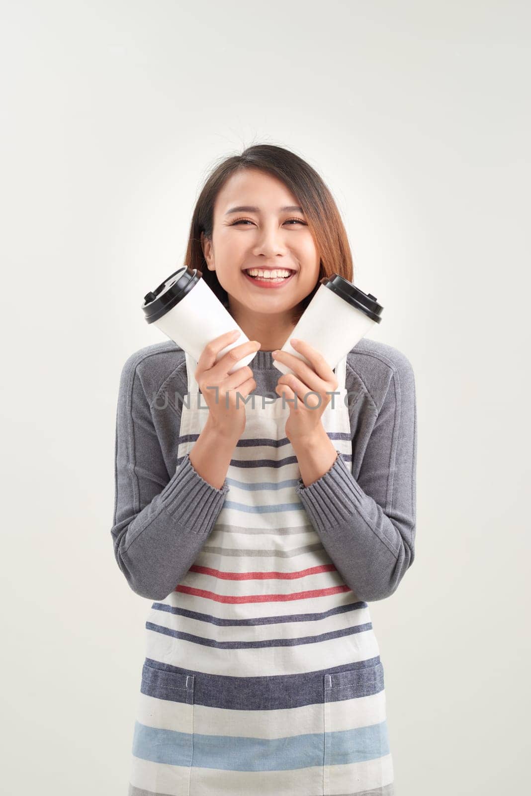 Close up photo beautiful amazing her she lady waitress owner cafeteria hold hands arms paper cups hot beverage invite visit cafe wear apron isolated white background