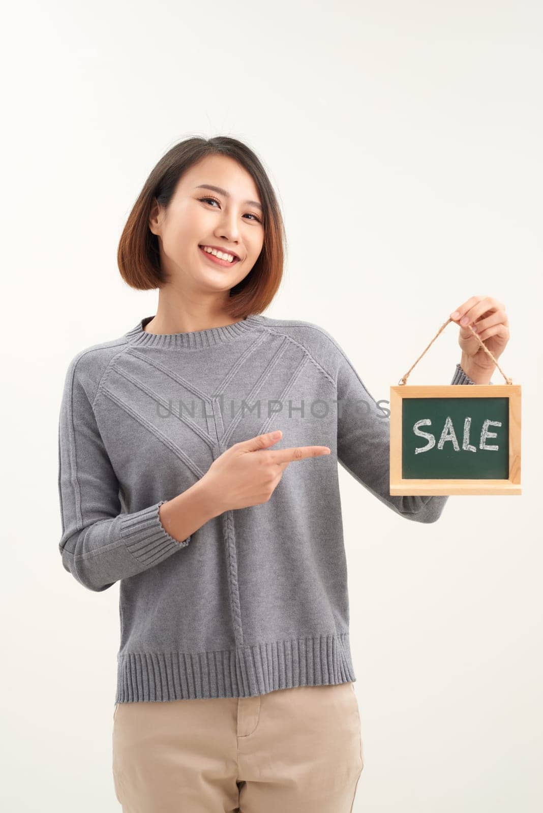 Woman finger point to chalkboard and showing sale word by makidotvn