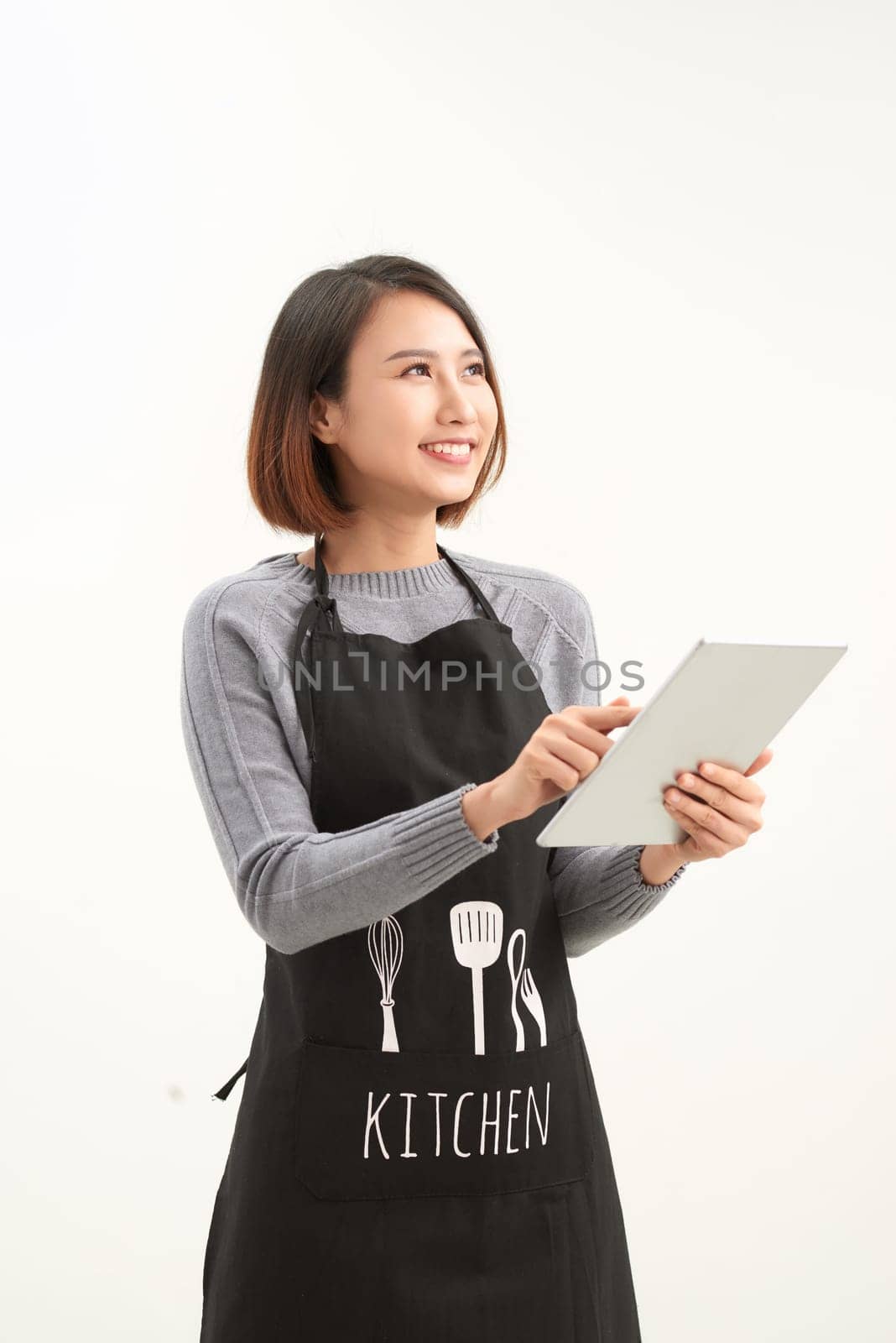 Happy small business owner in apron holding tablet standing against white background by makidotvn