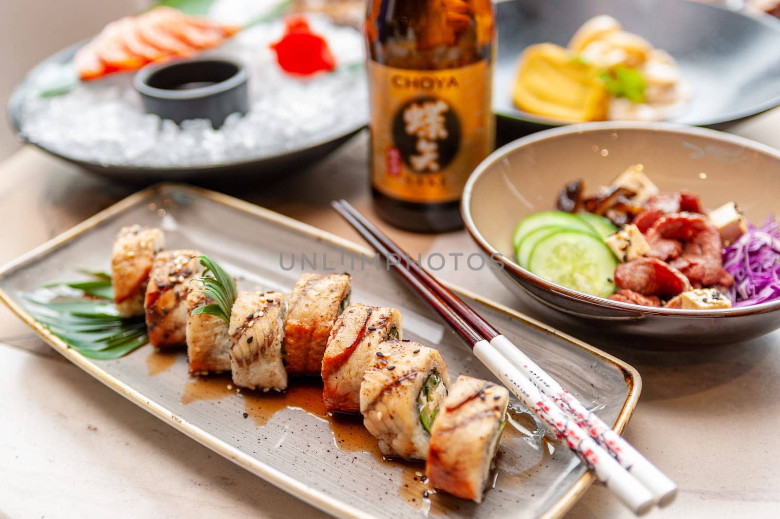 American canada sushi rolls with unagi and salmon on a table in a restaurant. High quality photo