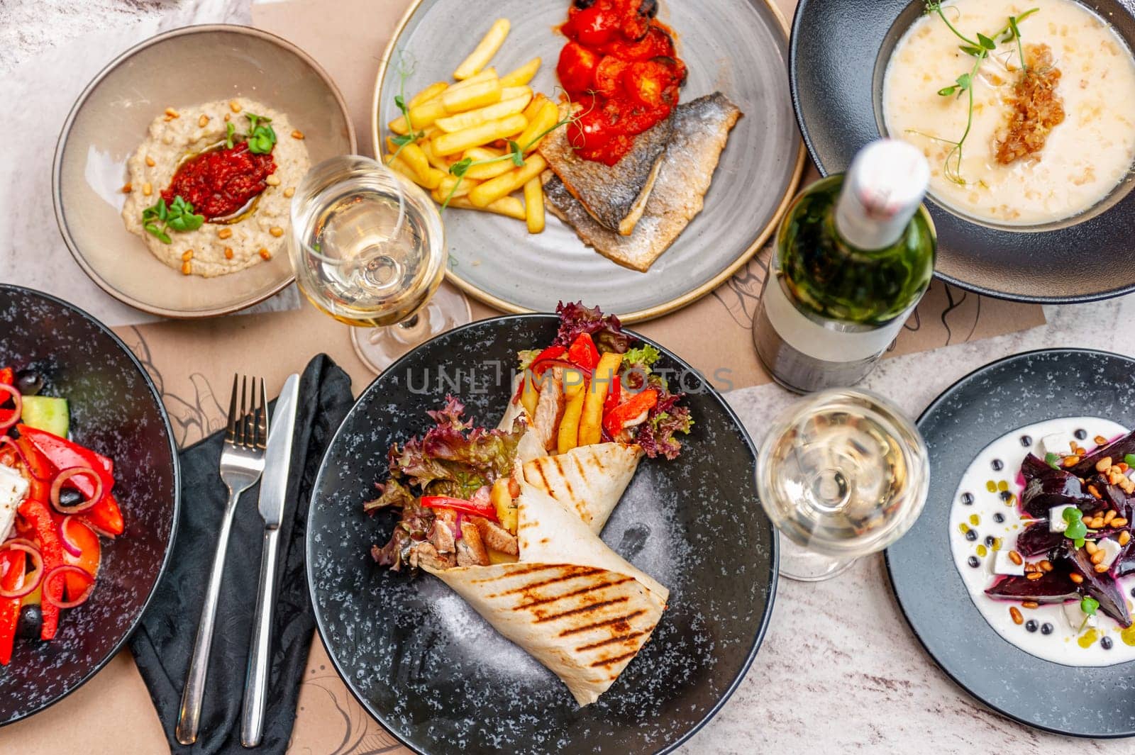 Set of Greek dishes, Mediterranean menu. Gyros, seabass or dorado fillet with French fries and tomato, Greek salad, orozo and herb soup. High quality photo