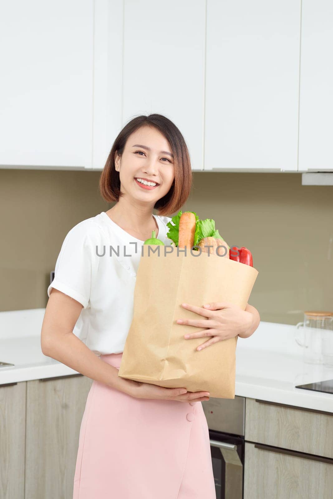 Happy Young Asian Woman with vegetables in shopping bag. Diet concept. 