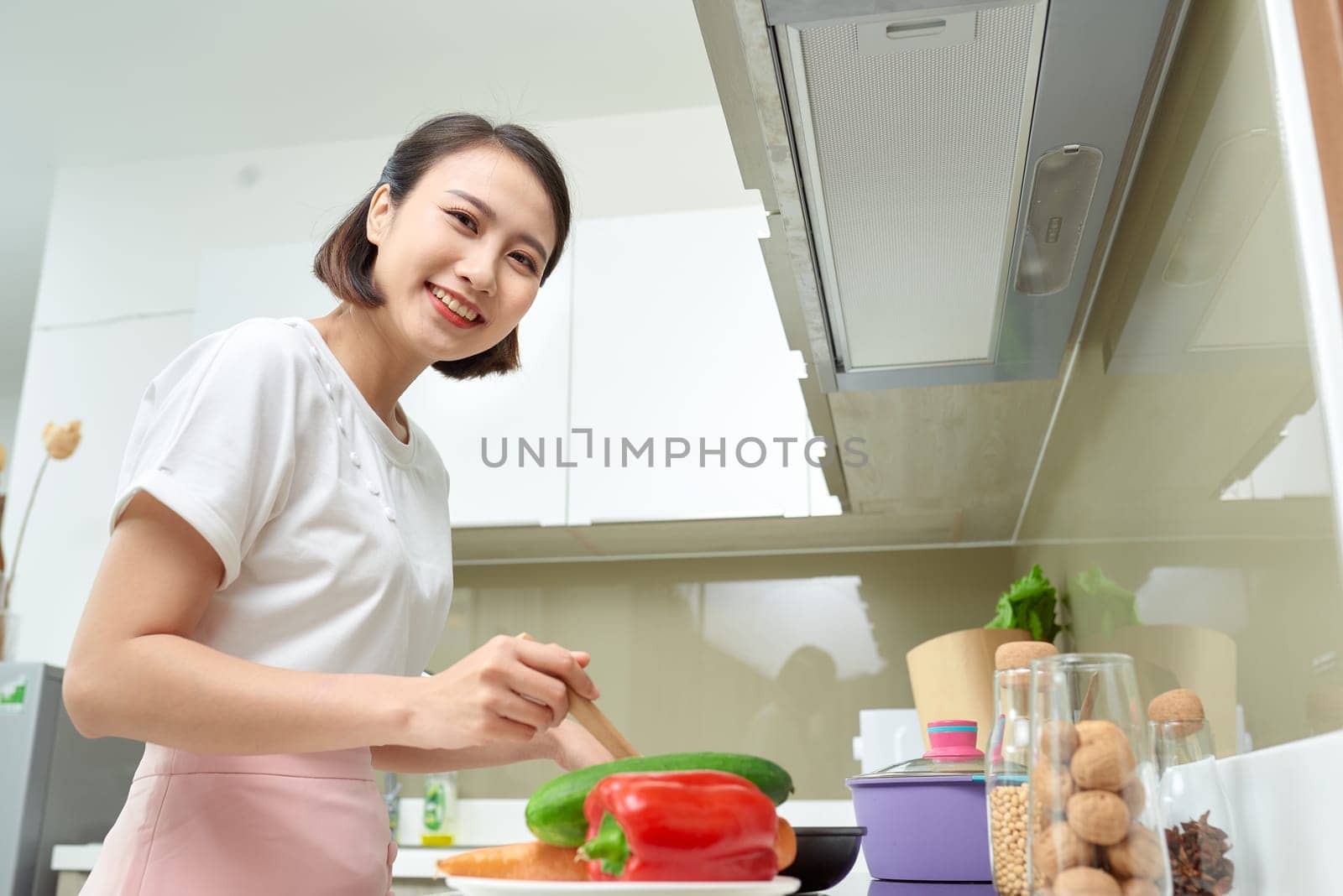 Happy Asian woman cooking in the kitchen.