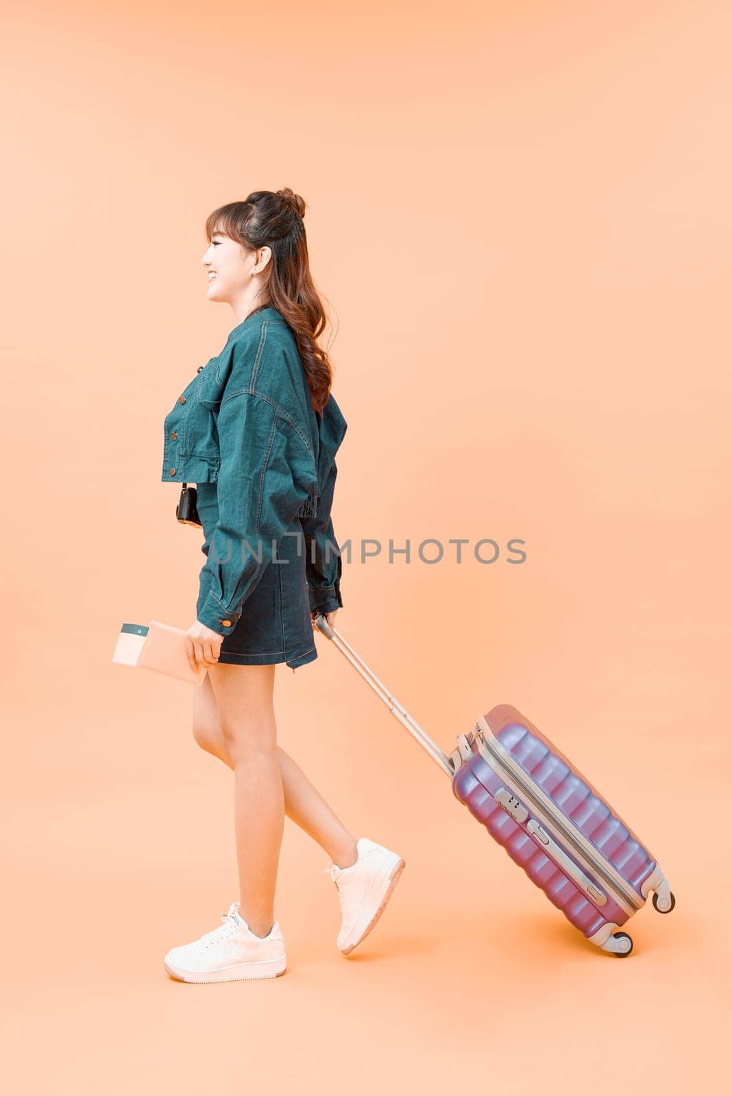 young female in casual walking with the travel bag, isolated on white background