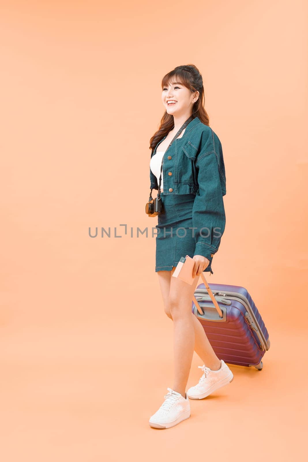 Young attractive woman tourist with a suitcase and tickets isolated  by makidotvn