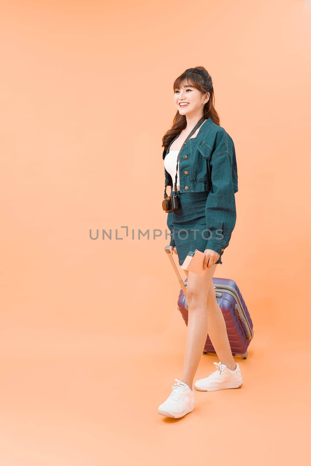 young female in casual walking with the travel bag, isolated on white background