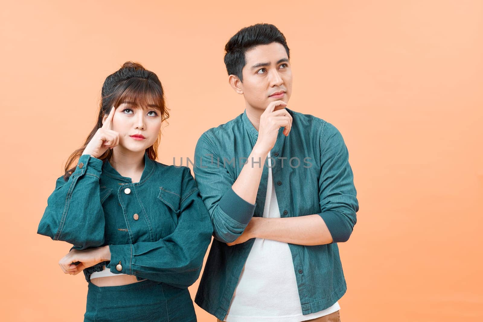 Portrait of pensive loving couple  thinking and looking away isolated over color background