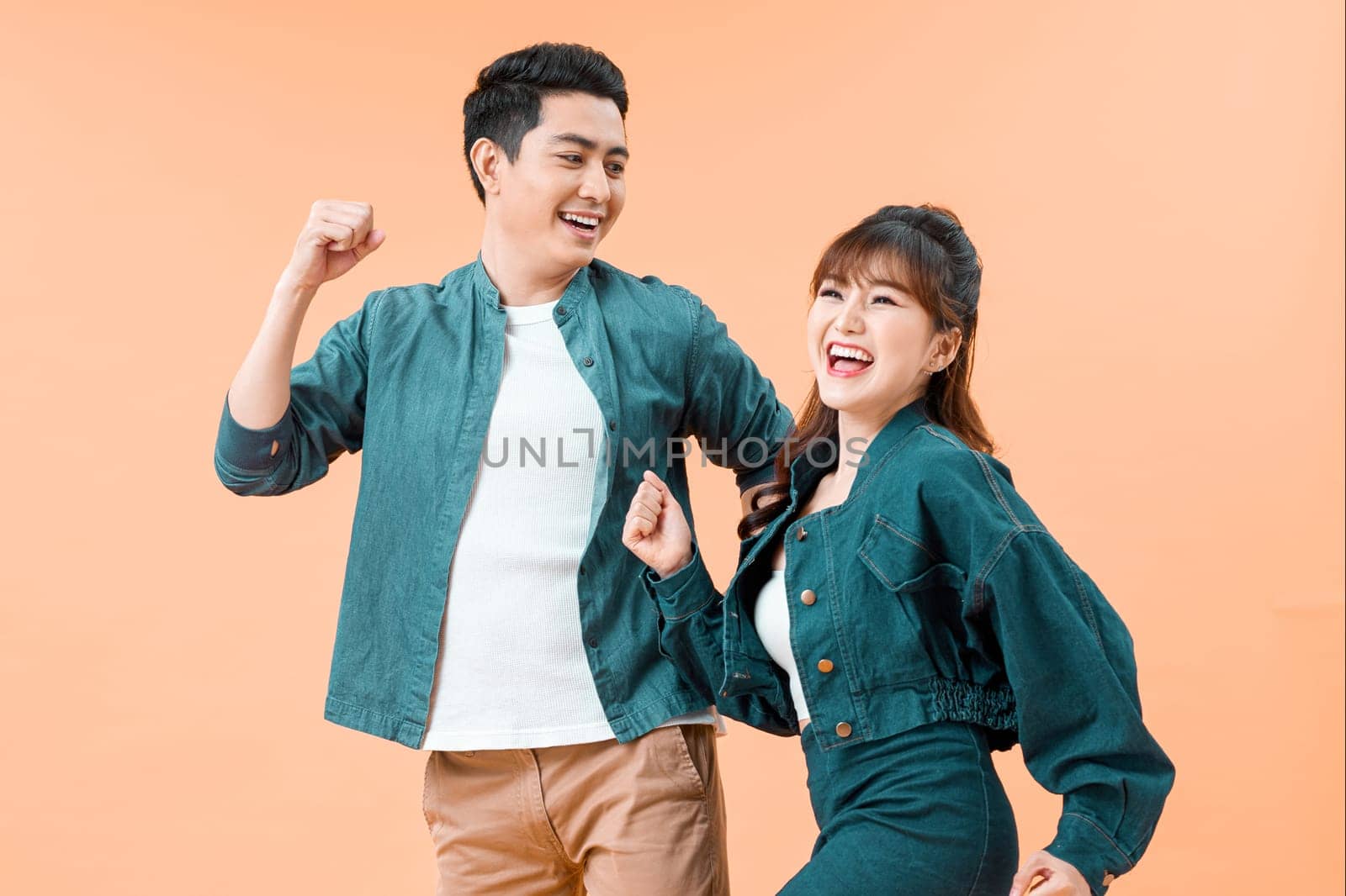 happy smiling couple isolated active jumping on color studio background,