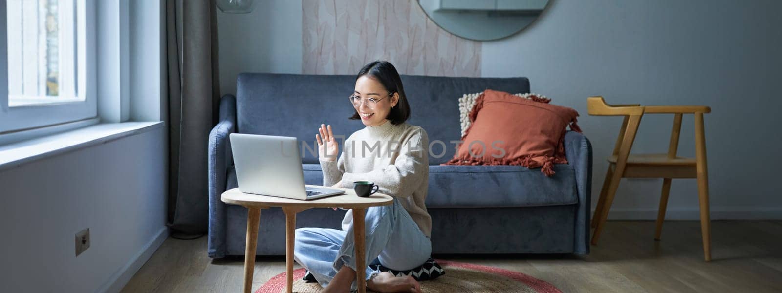 Portrait of young working woman, korean girl studying on remote online, talking to laptop, video chat, has conversation via computer application.