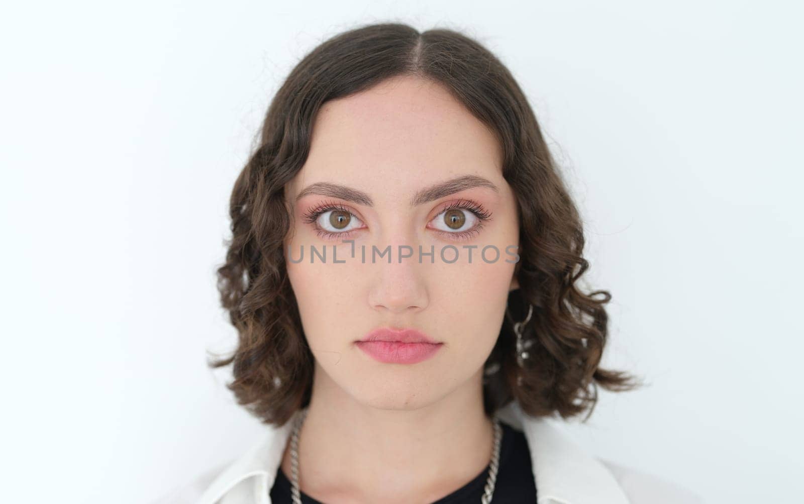 A stunning portrait of a young woman with curly hair, highlighting her beauty and unwavering confidence