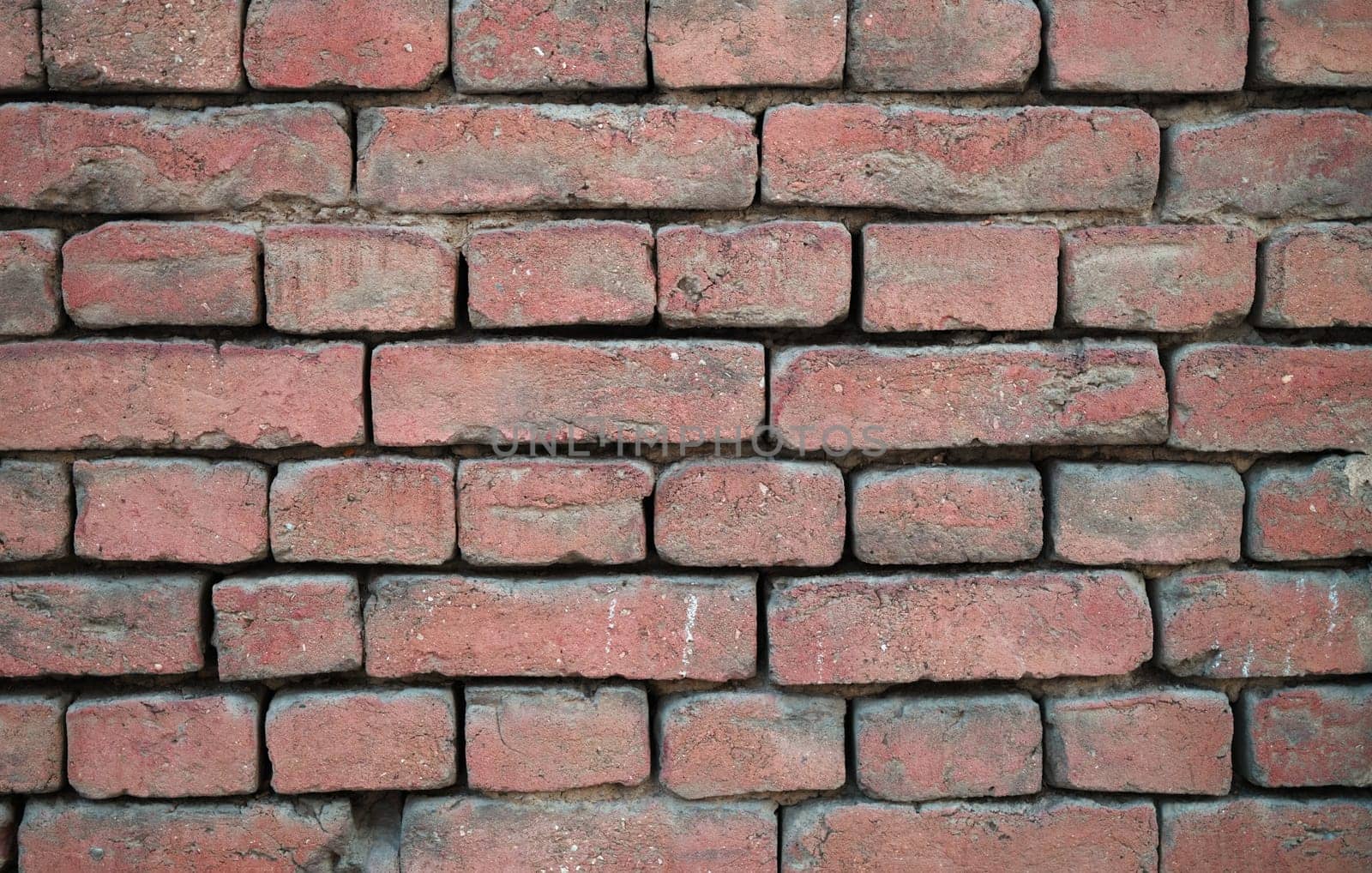 A closeup image showcasing a rustic red brick wall, which is ideal for a myriad of design and architectural projects