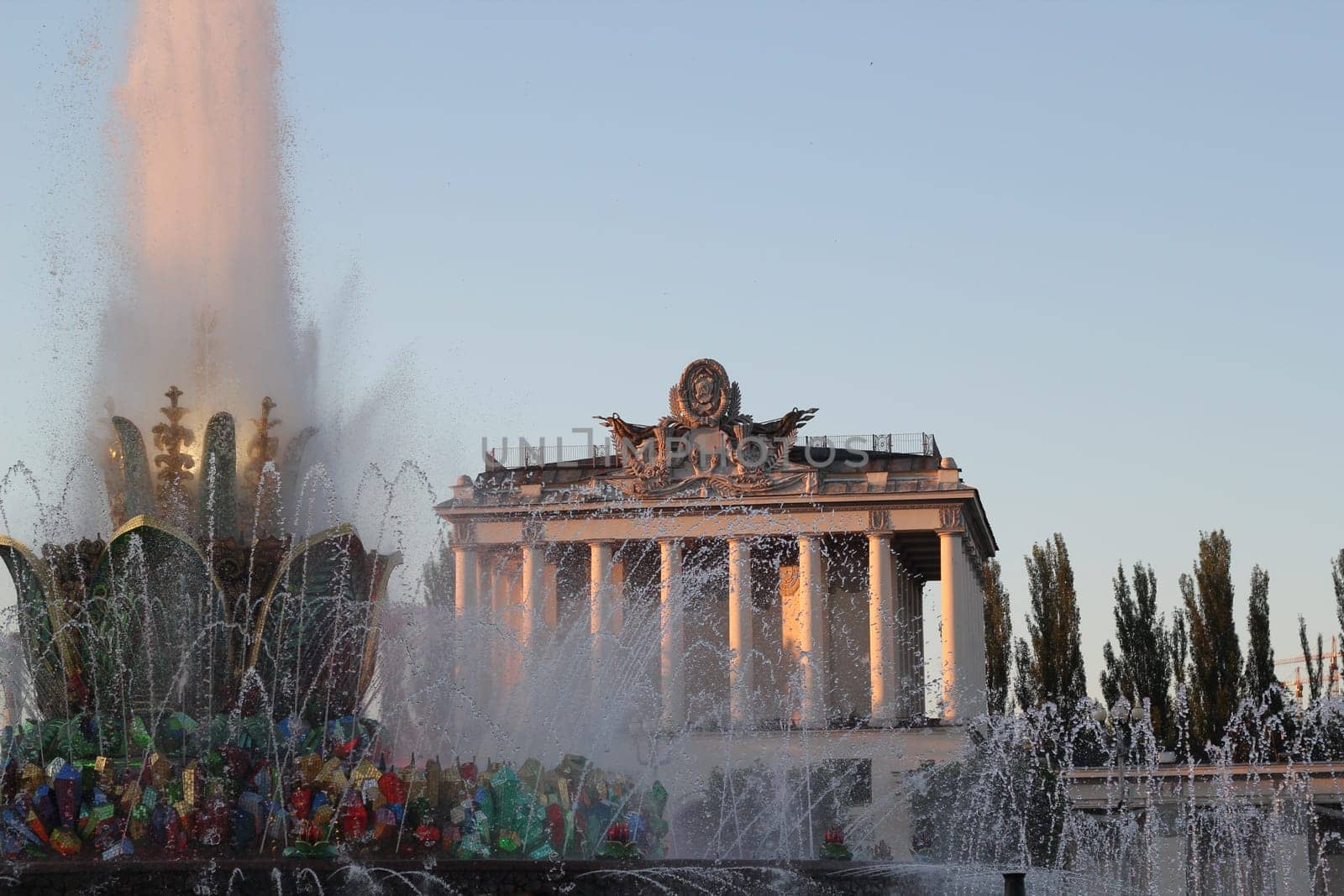 A stunning fountain lit at night, displaying vibrant colors against a backdrop of historic architecture