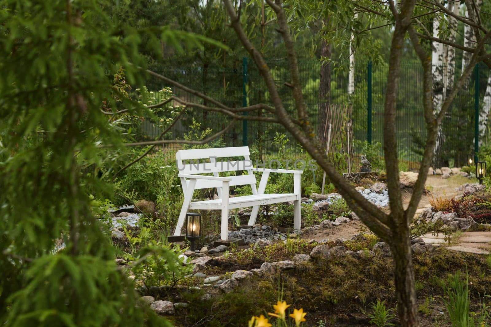 A serene and peaceful white bench gracefully nestled among lush green foliage and enchanting natural beauty