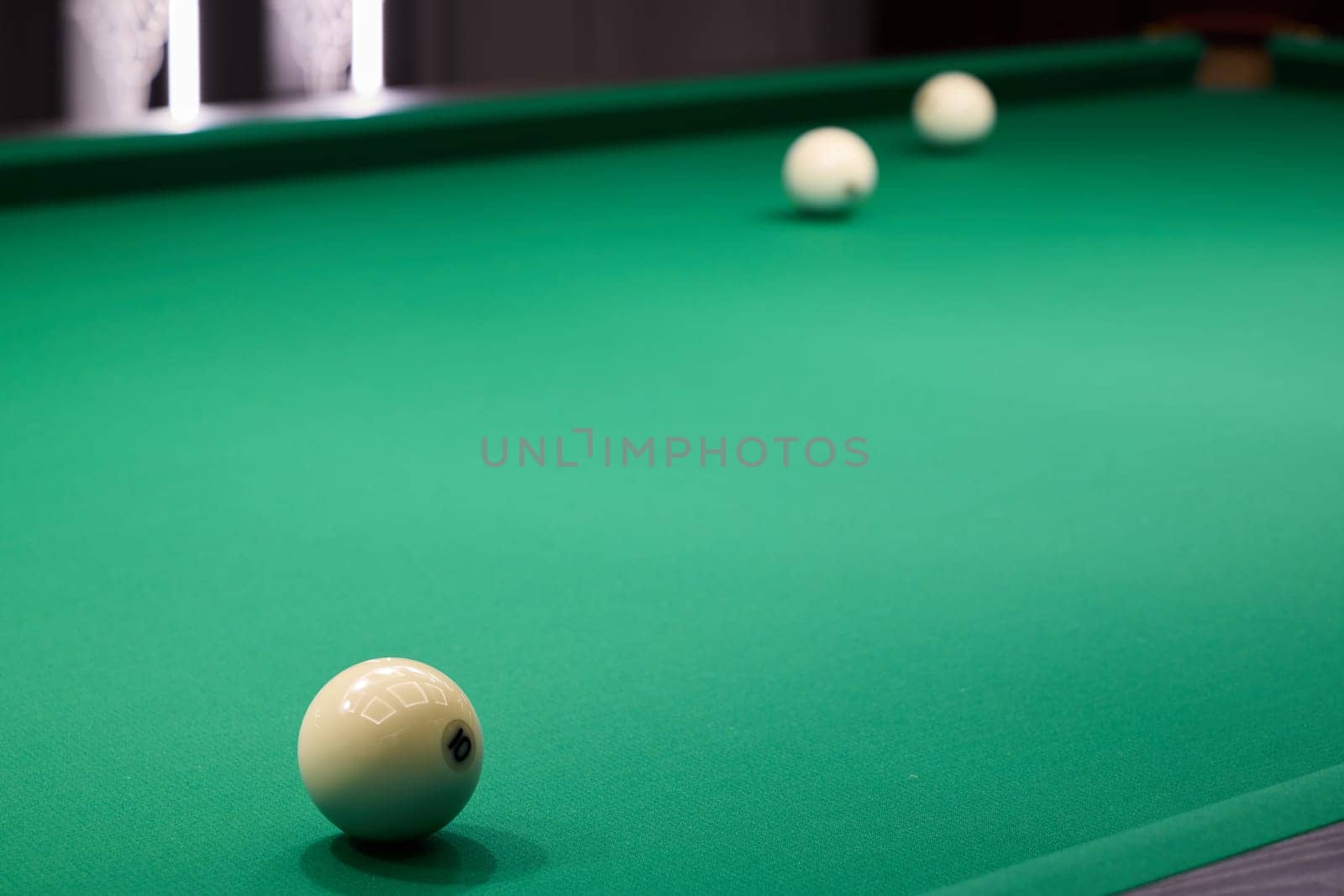 This image shows colorful billiard balls arranged on a green pool table, highlighting the depth and texture