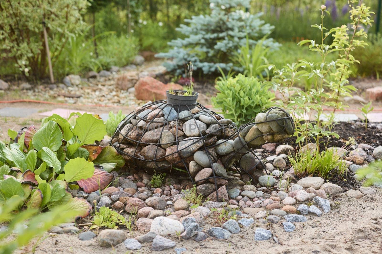 A unique turtle sculpture, made of beautiful stones, harmoniously blends into a vibrant, lifefilled garden