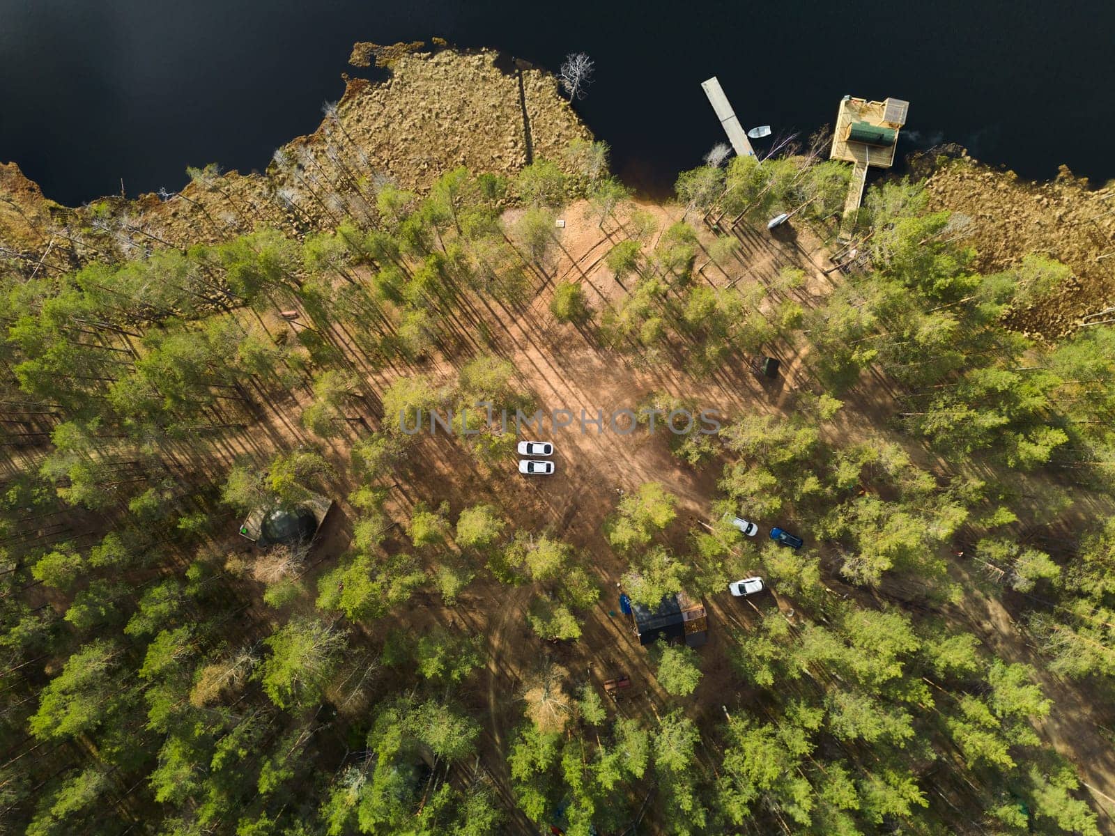 An aerial view beautifully showcasing a tranquil and peaceful campsite nestled amidst lush greenery and calm waters