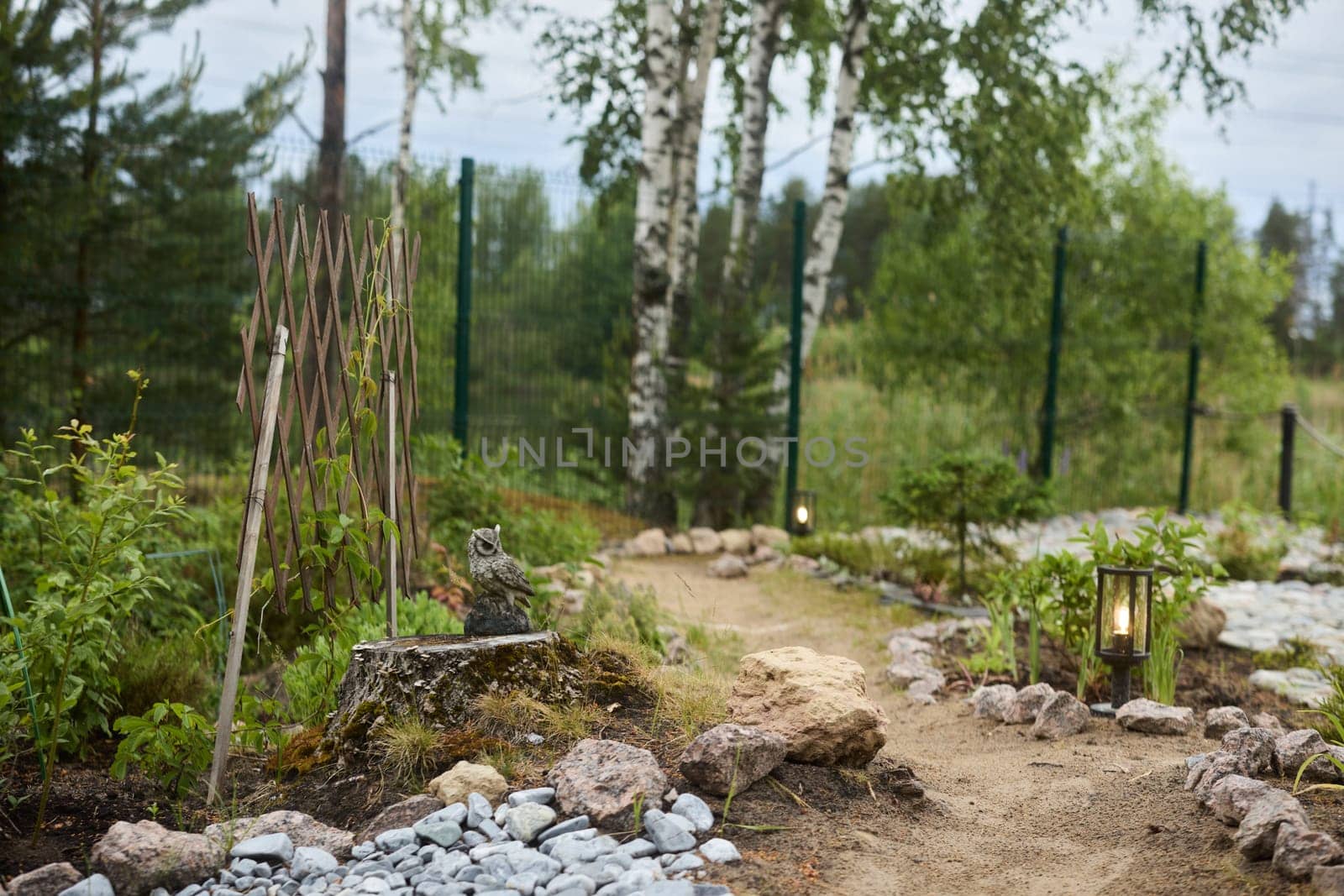 A serene, tranquil garden path that is beautifully surrounded by lush greenery and various natural elements