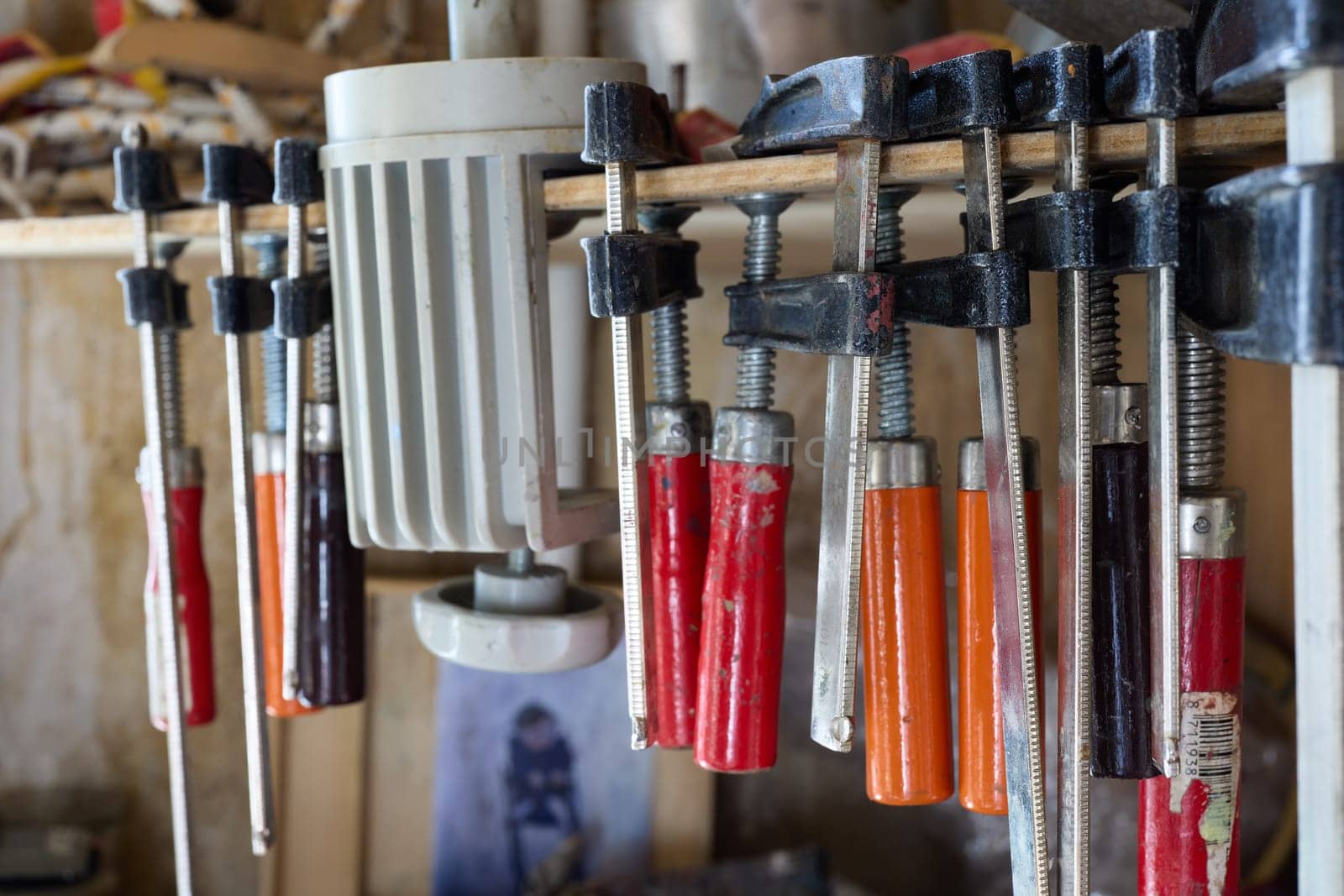 This closeup shows various clamps and tools in a workshop, highlighting craftsmanship and skilled techniques