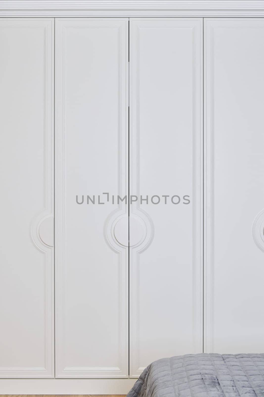 This modern wardrobe features sleek white doors with circular handles, combining elegance and functionality