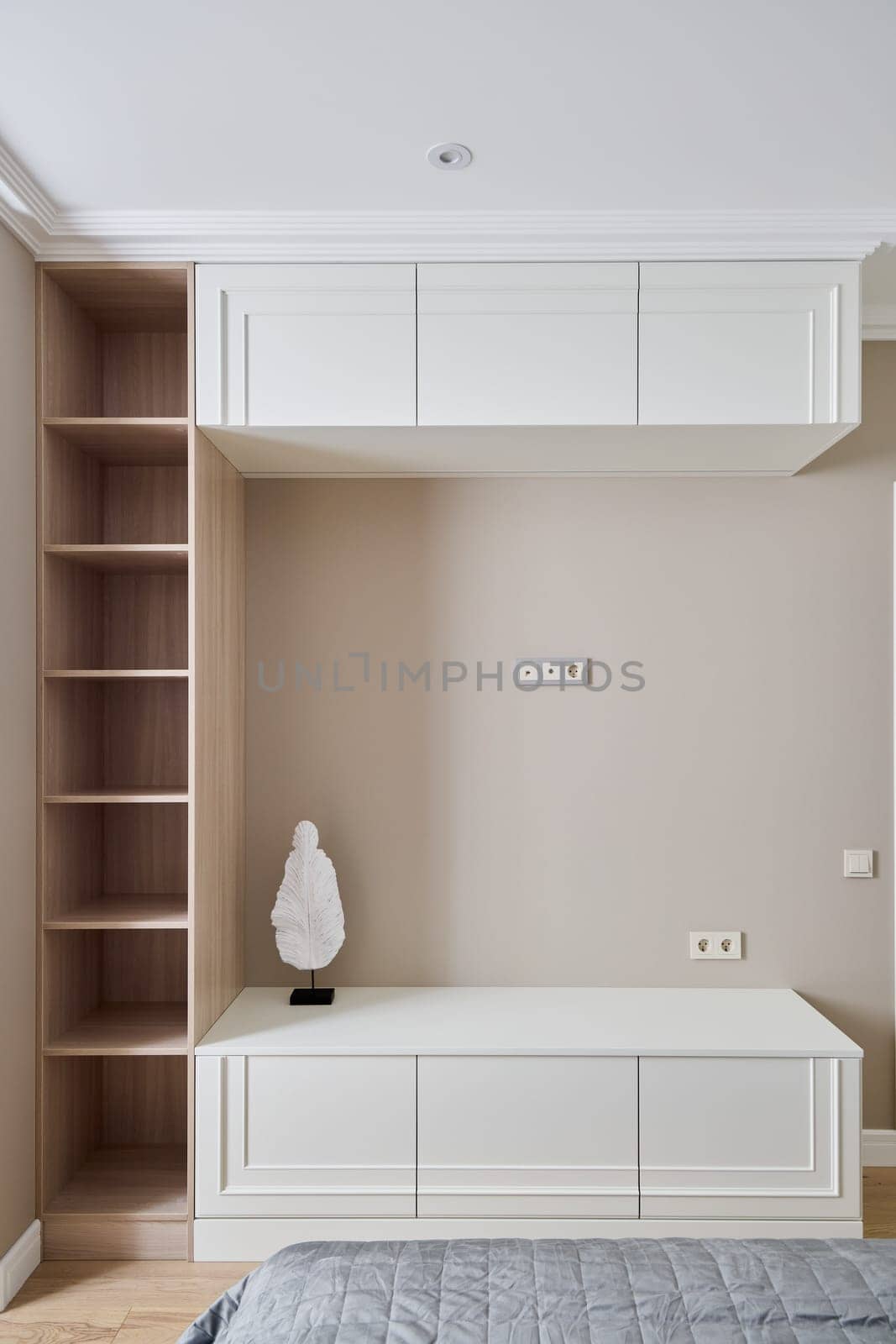 A sleek and modern wall unit featuring white cabinetry and an artistic decorative statue for added design flair