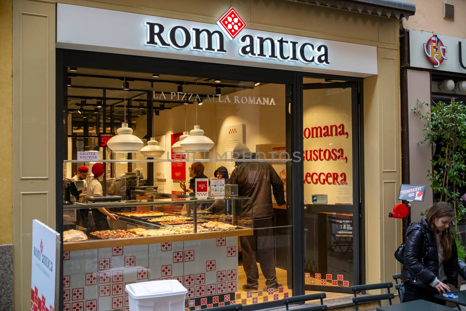 Cremona, Italy - November 20th 2024 Chefs preparing and serving pizza al taglio at romantica pizzeria in cremona, italy