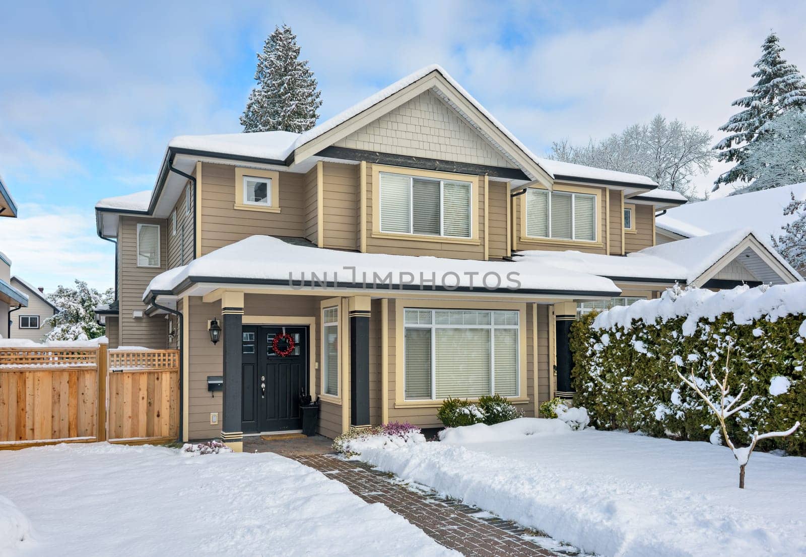A perfect neighborhood. Entrance of nice residential house on winter season. Snow covered front yard of residential house in British Columbia, Canada