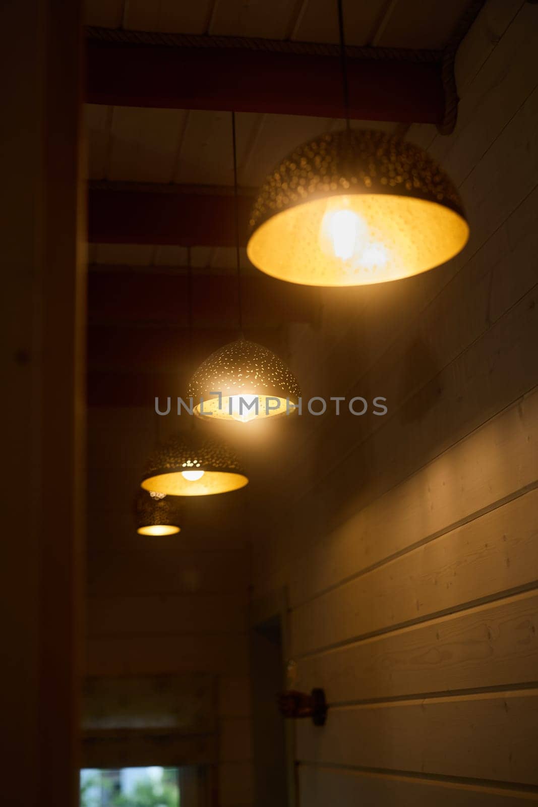 Charming pendant lights gracefully illuminate a serene hallway, creating an inviting and modern touch to the space
