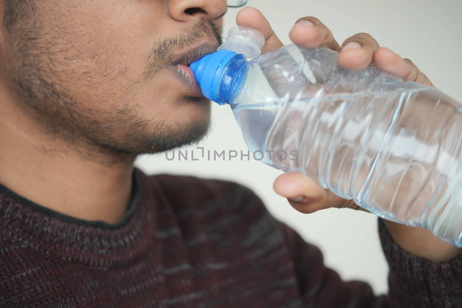 A detailed closeup image capturing an individual as they drink water for essential hydration