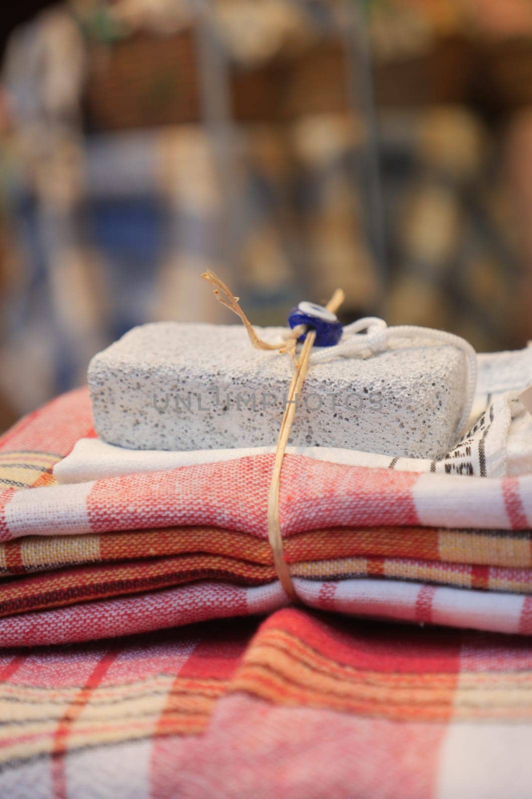A visually pleasing display of beautiful textiles and a decorative stone in a market setting
