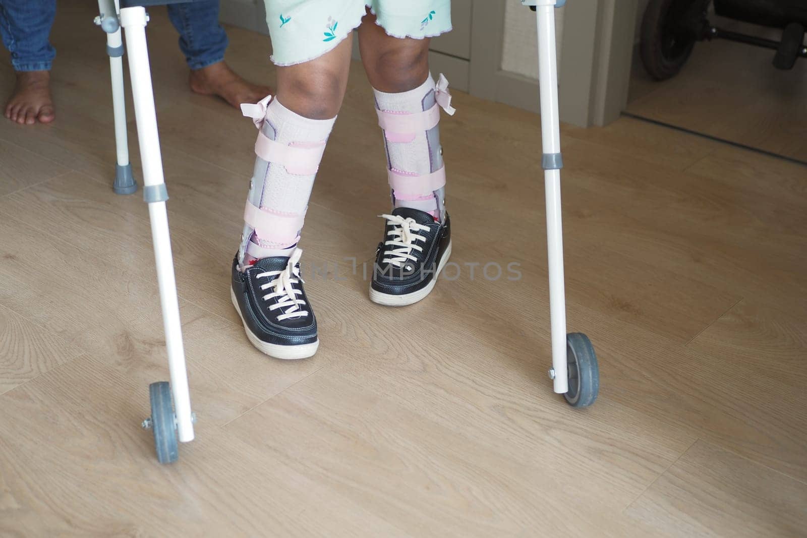 Young Child Using Walker for Supportive Mobility Indoors.