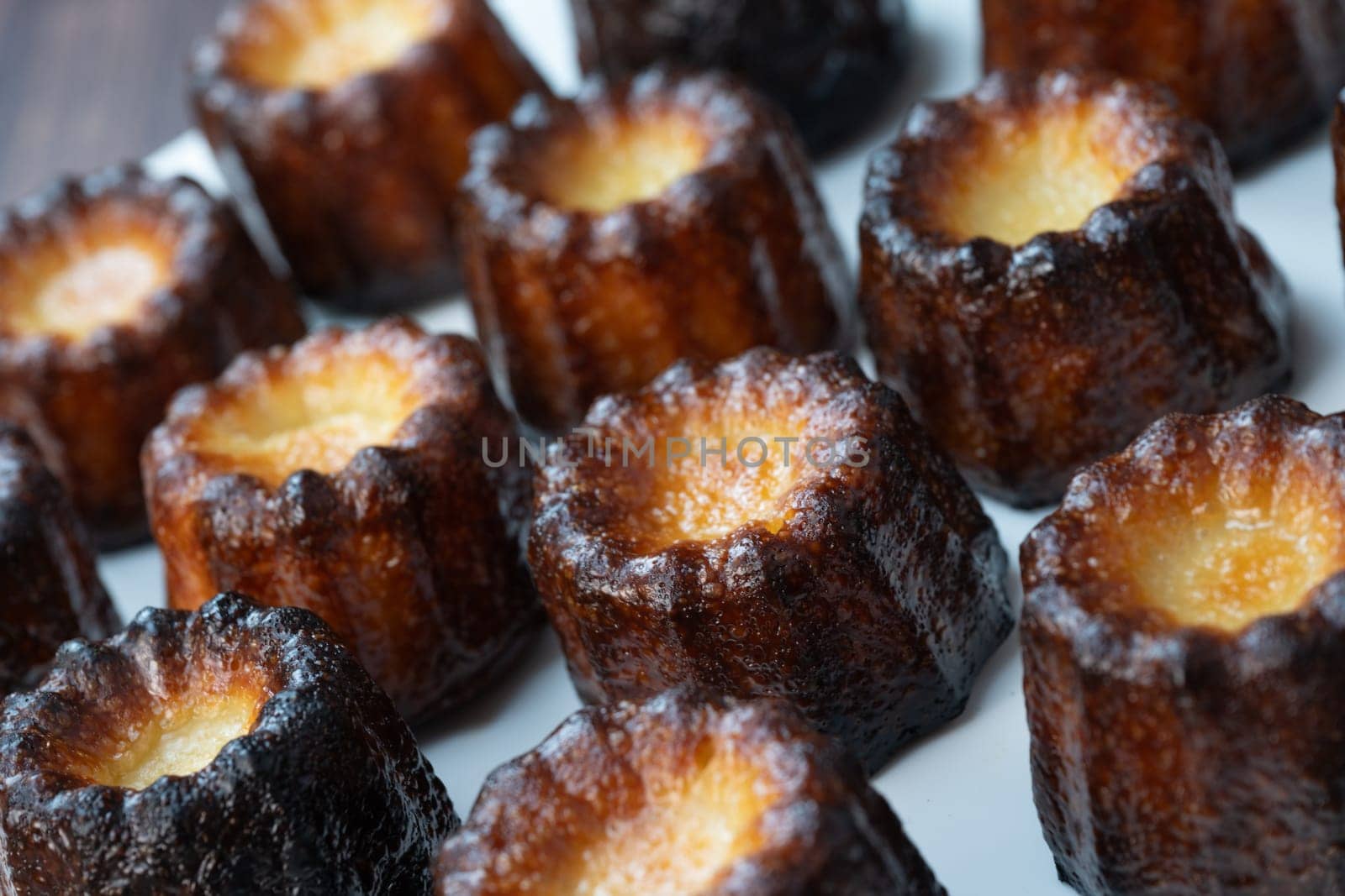 Caneles de bordeaux, traditional French sweet dessert with white table background, High quality photo