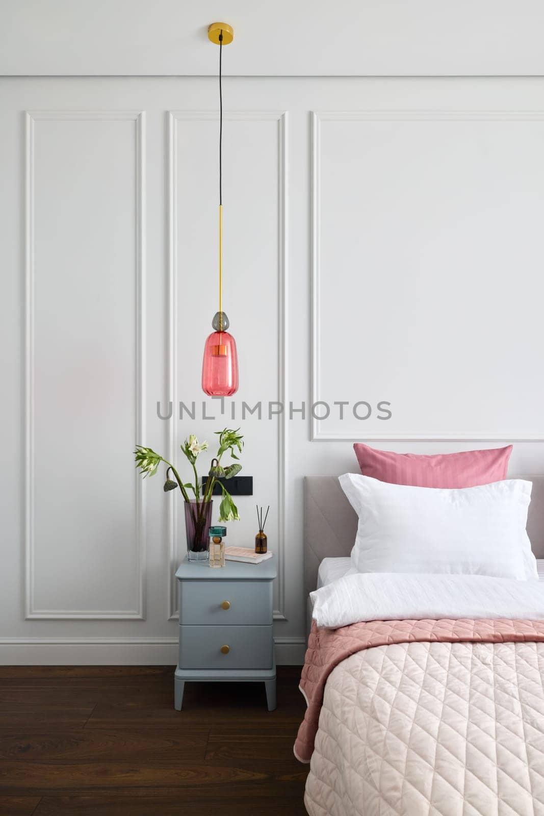 A modern bedroom featuring chic decor and a stunning pendant light, creating a cozy ambiance for relaxation