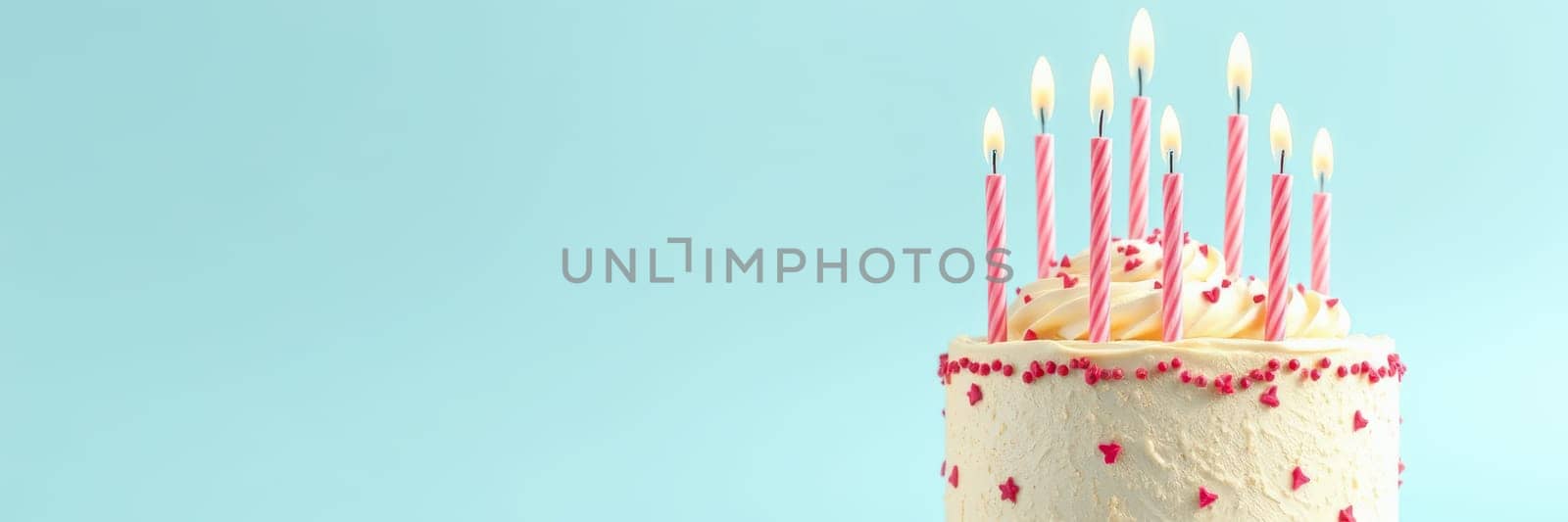 A beautifully designed birthday cake topped with colorful candles ready for a celebration. The light blue background enhances the festive atmosphere of the occasion.