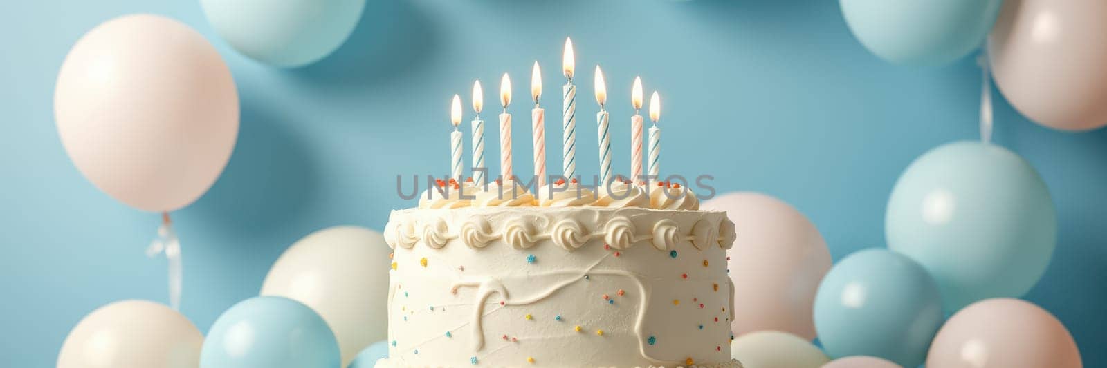 A delicious birthday cake with lit candles sits on display, surrounded by pastel balloons that enhance the joyful atmosphere of a birthday celebration.