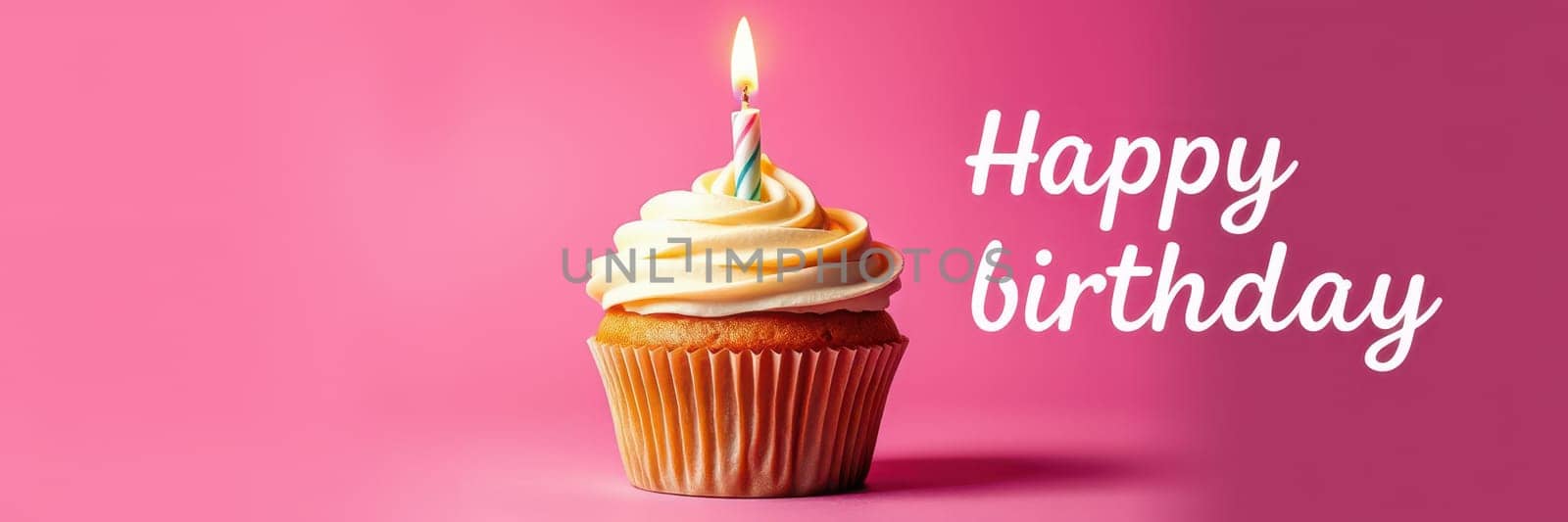 A delicious cupcake sits on a pink backdrop, adorned with creamy frosting and a single lit candle, celebrating a joyous birthday moment.