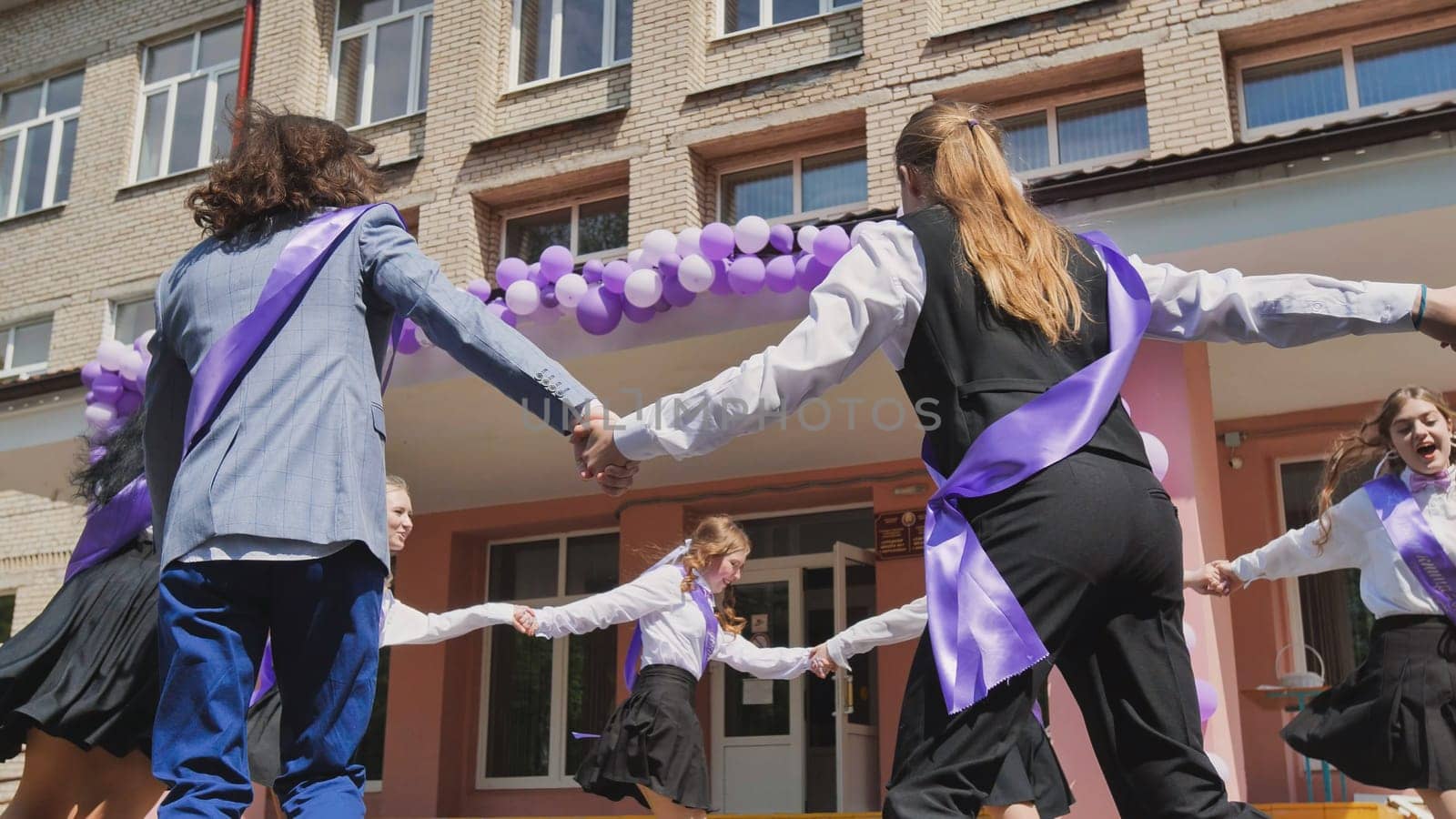 Graduates perform a traditional dance outside their school to mark the end of the school year and celebrate their graduation