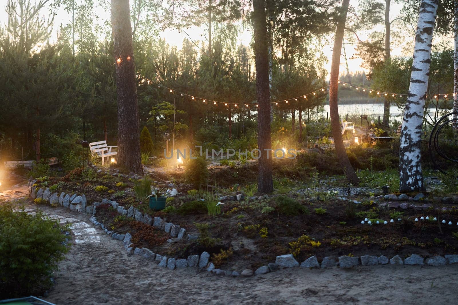 A serene garden, lit warmly at dusk, ideal for relaxation and enjoyable gatherings with friends and family