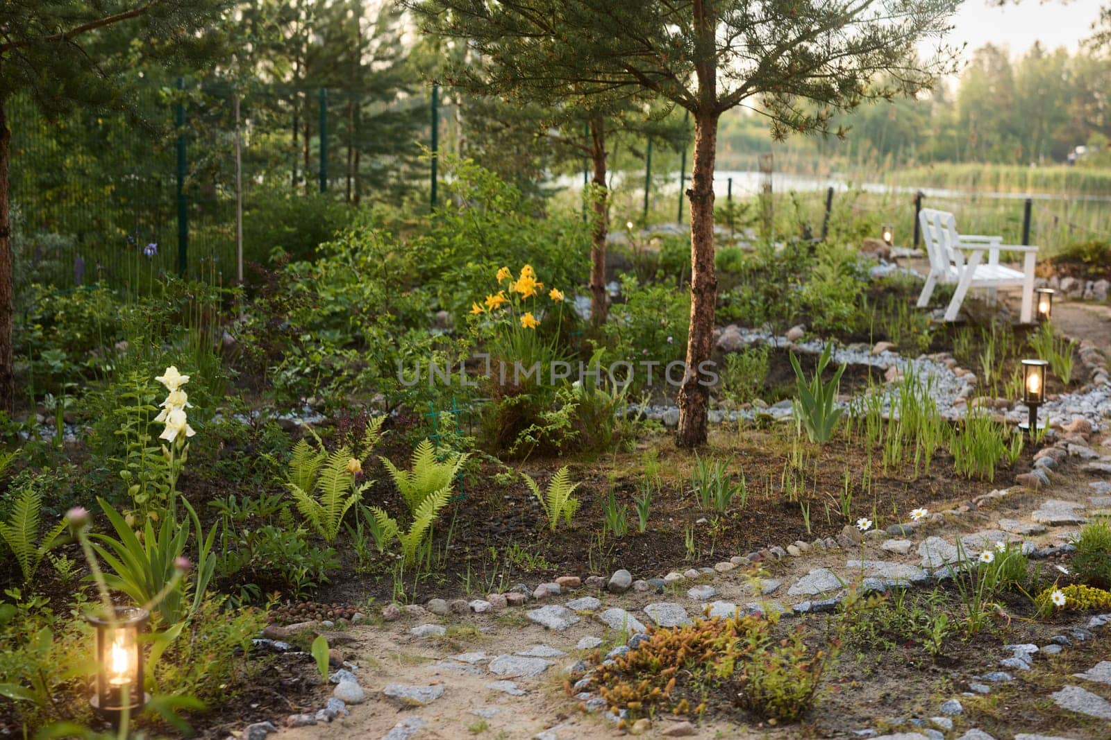 A beautifully tranquil garden scene featuring a winding path and vibrant blooming flora by the calming water