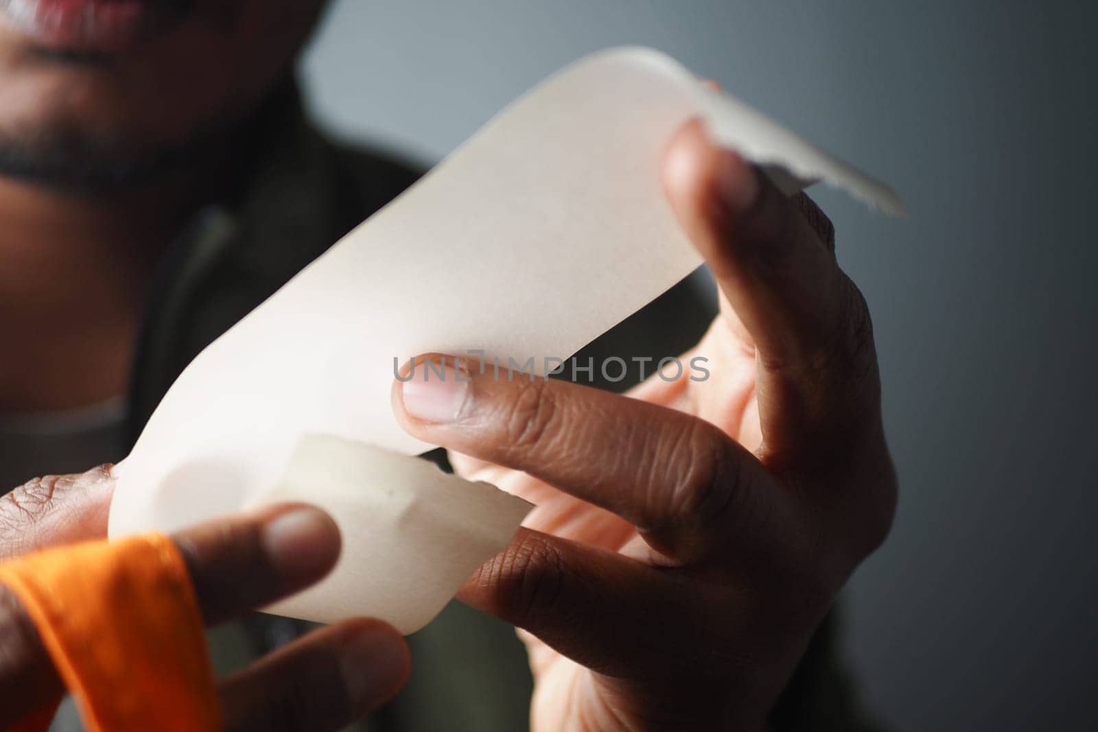 Close-Up of Hands Holding Receipt and Grocery Bag.