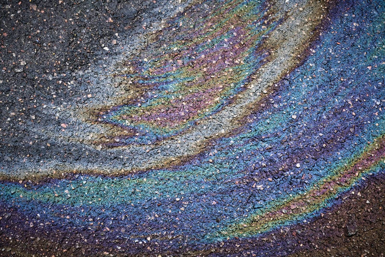 Bright oil stain creating a colorful stain on asphalt.
