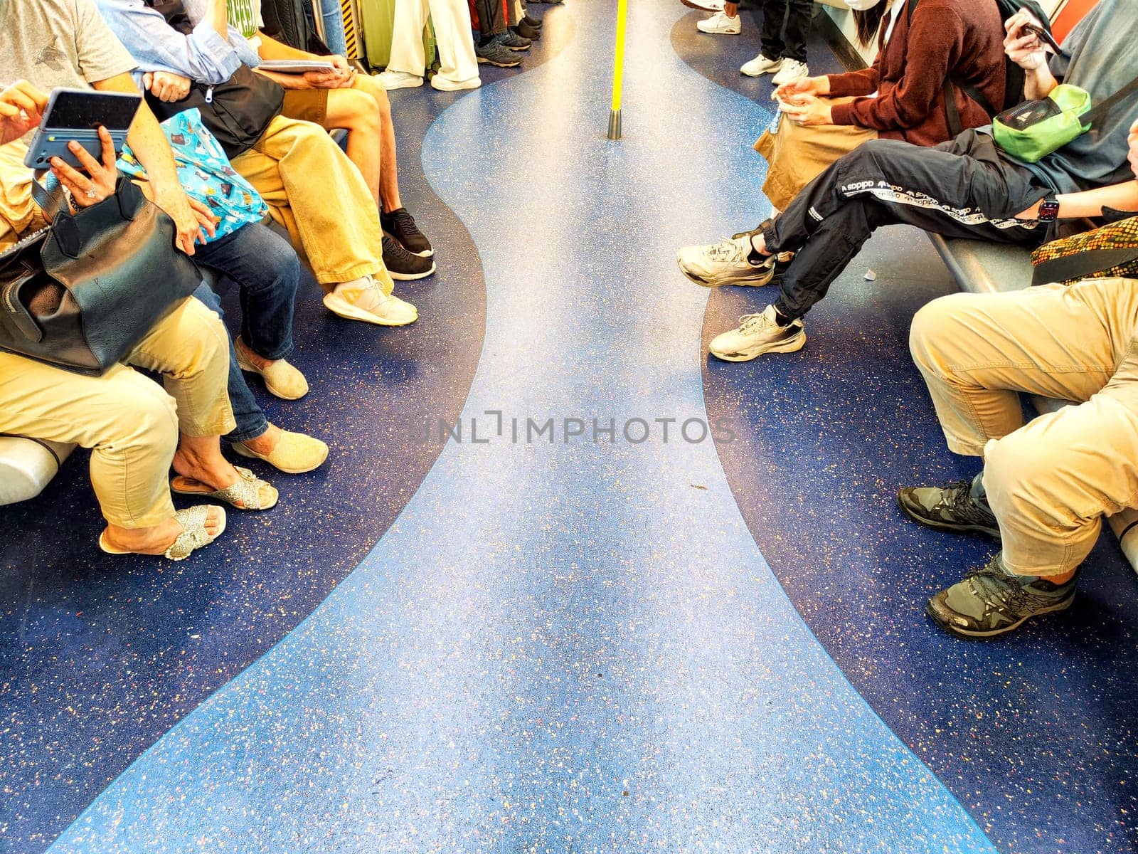 Hong Kong, China - April 09, 2024: Visitors at the metro occupy seats on public transport, engaged in their own activities while traveling to their destinations.
