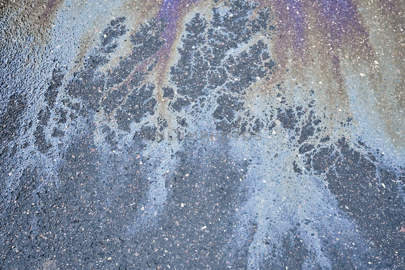 Multicolored oil sheen on the asphalt, creating an attractive abstract pattern.