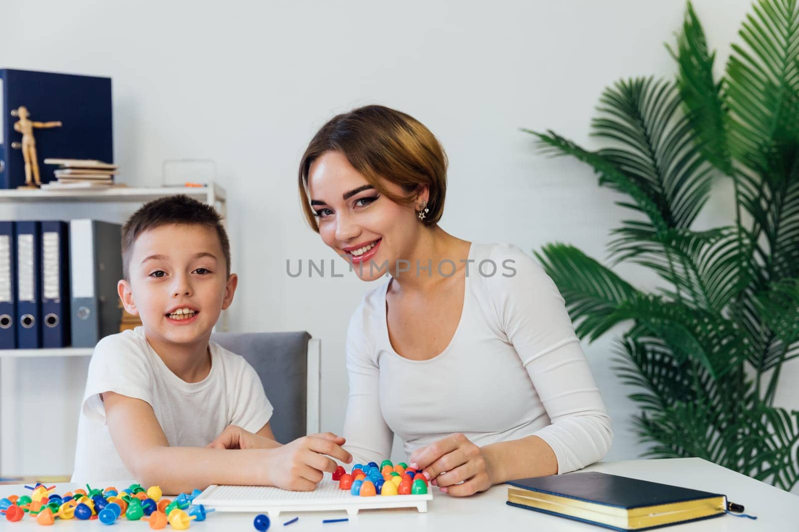 Woman Playing With Boy Educational Games On Table