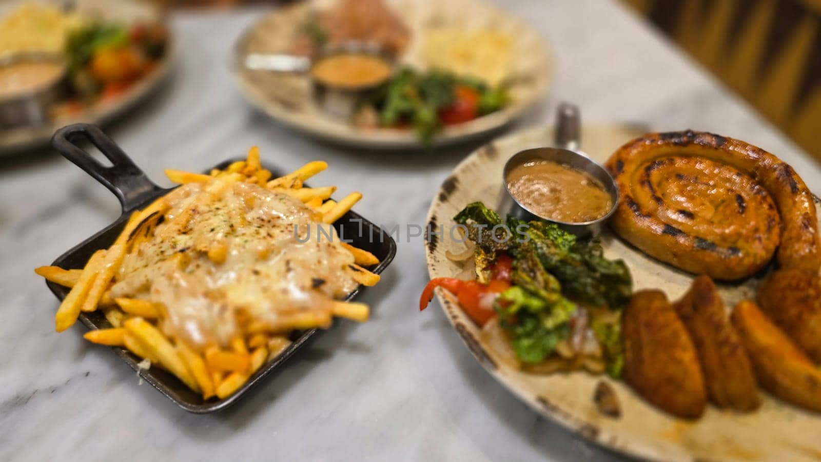 mouthwatering German worst curled up cumberland sausage meal featuring a grilled sausage, loaded cheese fries, and fresh vegetables served on a rustic plate. Perfect for dinner lovers appreciating hearty and flavorful dishes.